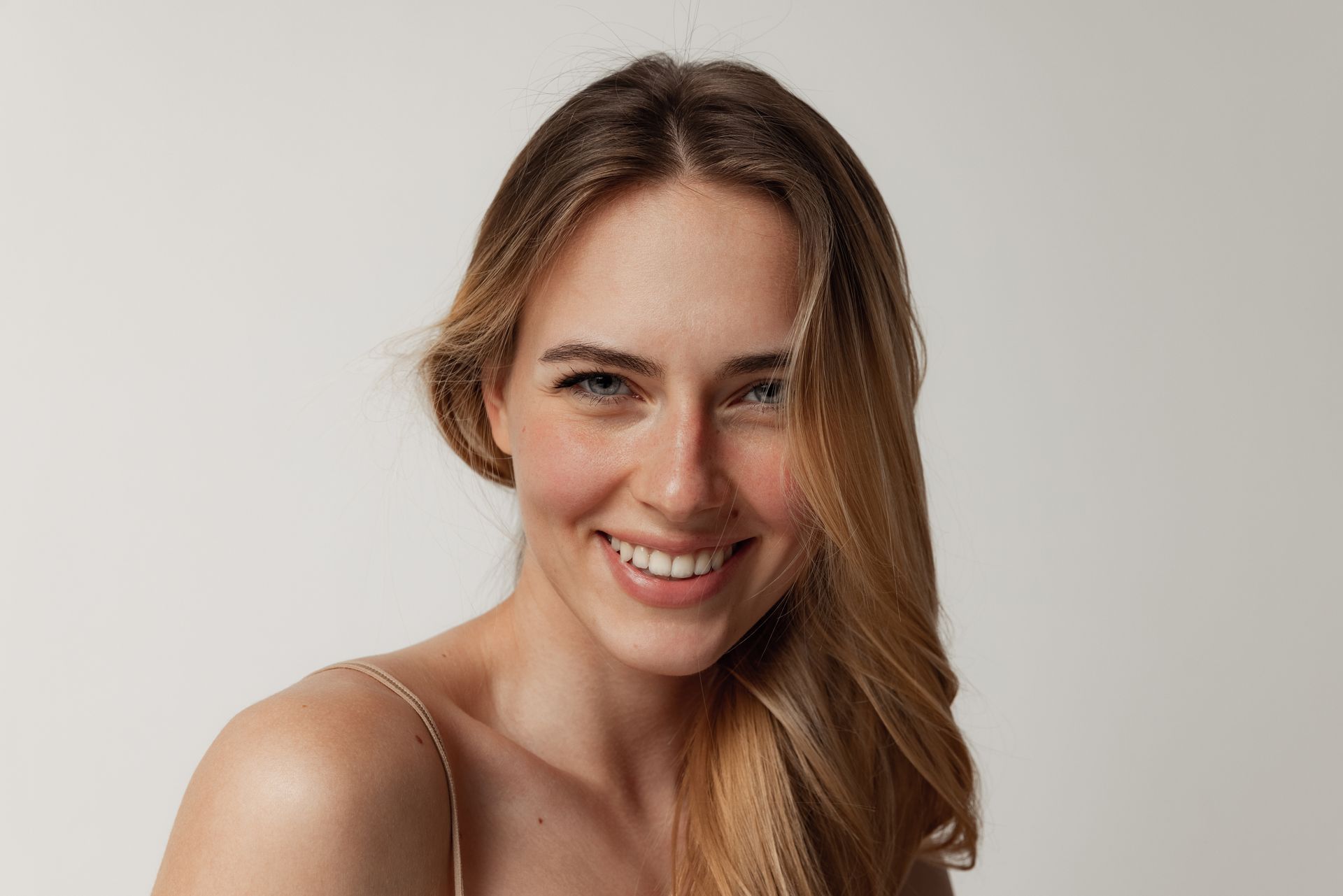 a woman with long hair is smiling and looking at the camera .