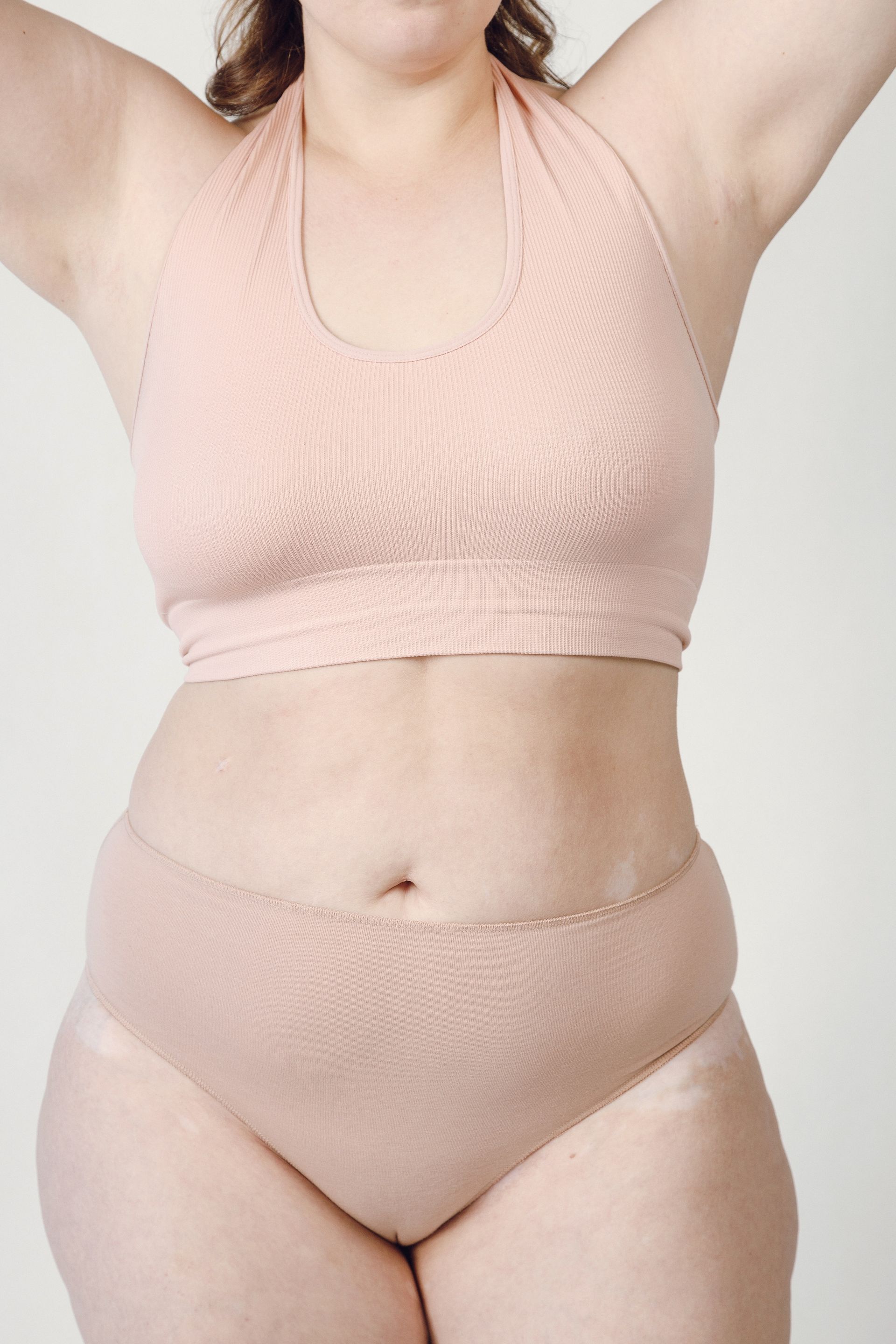 a woman is wearing a pink bra and panties .