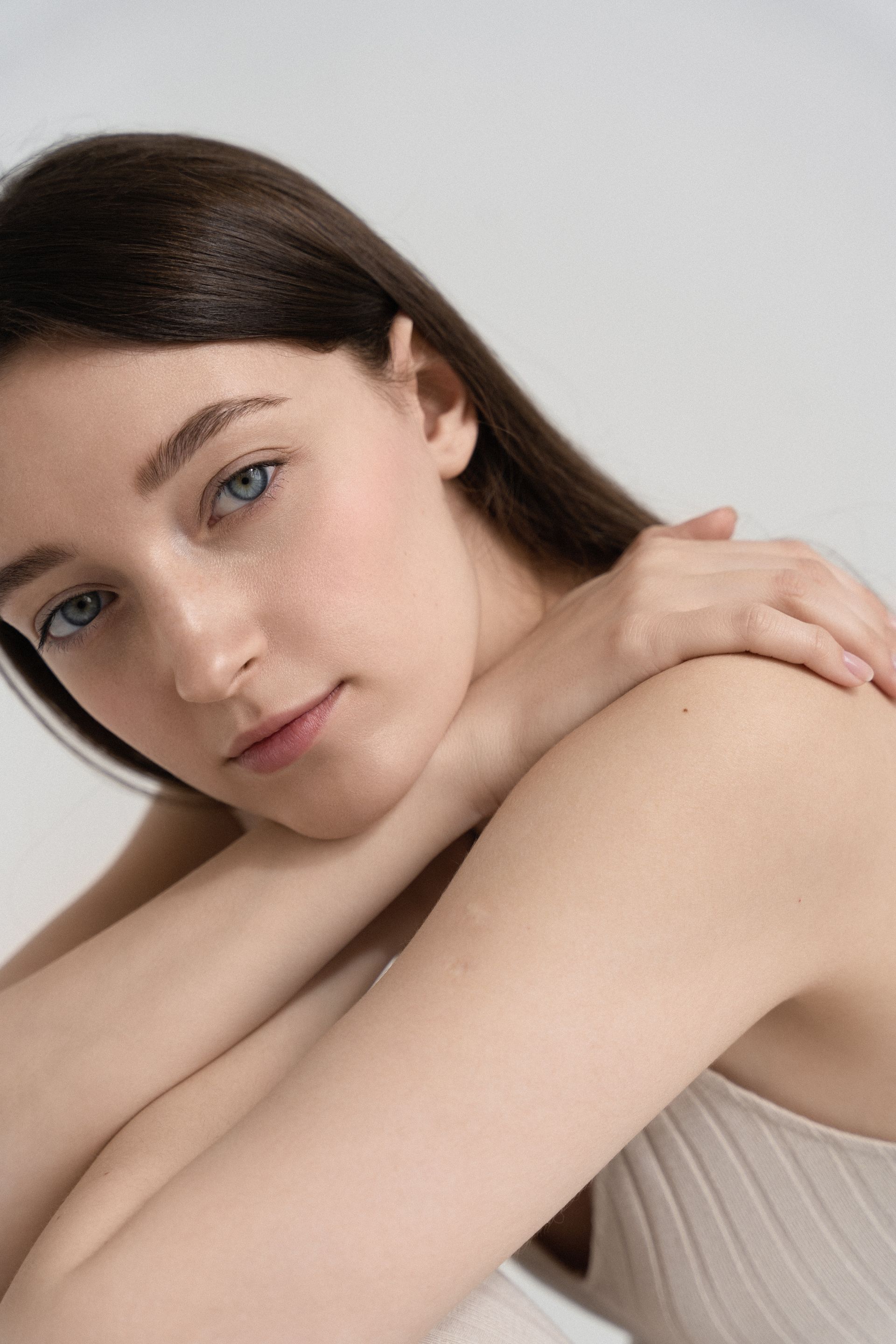 a close up of a woman 's face with her hands on her shoulder .