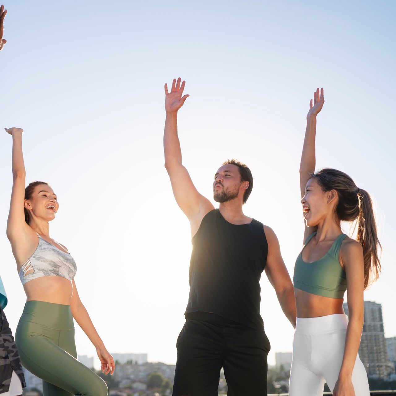 A group of people are standing with their arms in the air