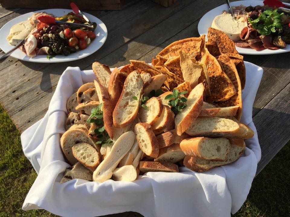 Basket of Assorted Bread Slices With Two Plates of Appetizers on a Table — Amanda Douglass Catering Service in Corlette, NSW
