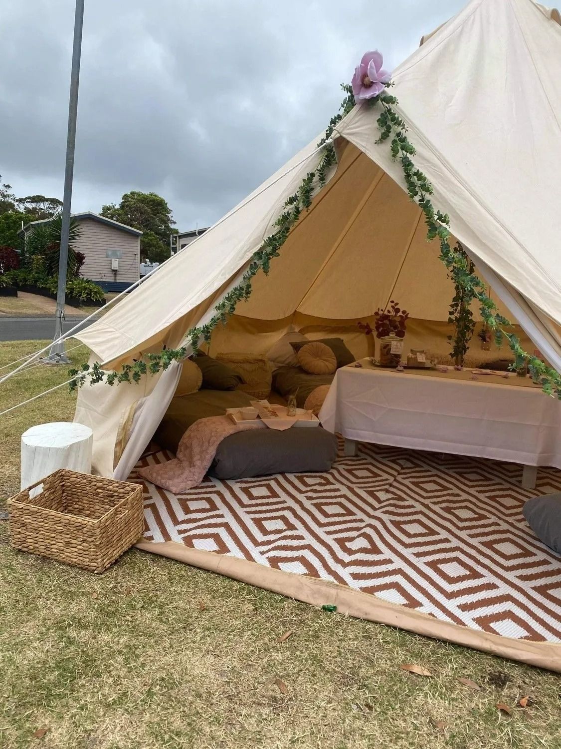 A Decorated Glamping Tent Set Up on a Lawn With a Table and Cushion — Amanda Douglass Catering Service in Corlette, NSW