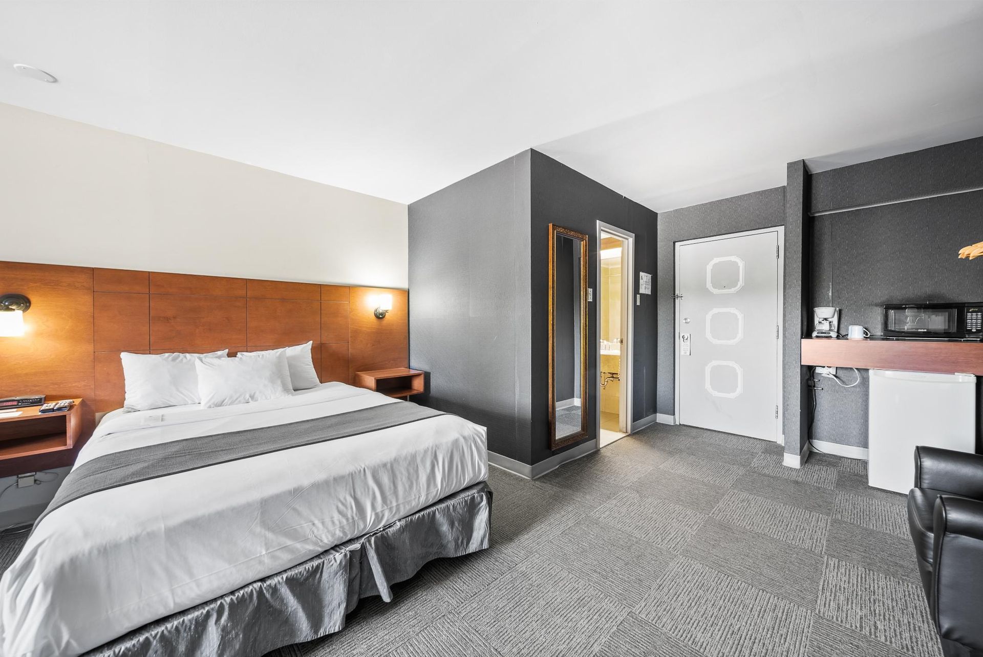 Une chambre d'hôtel avec un lit king size et une cuisine.