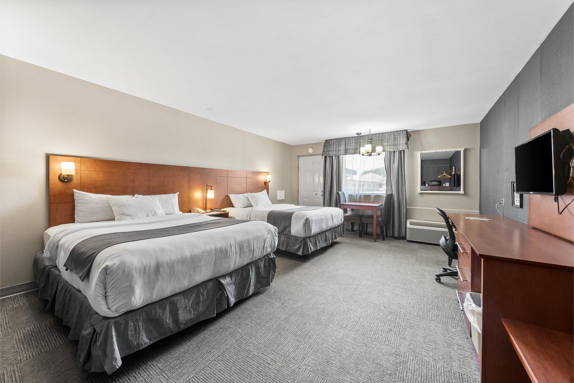 Une chambre d'hôtel avec deux lits, un bureau et une télévision.