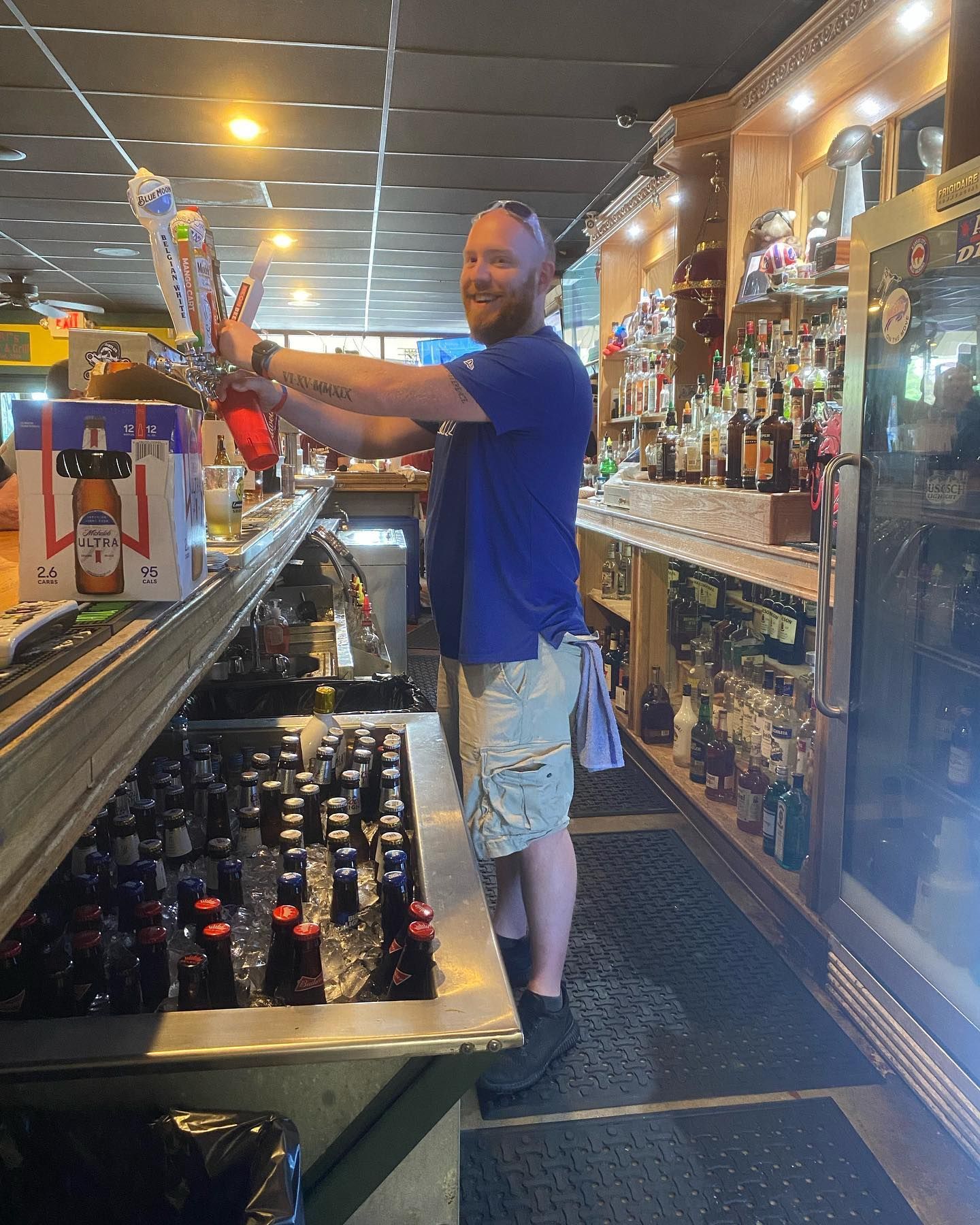 A bartender is pouring beer into a glass in a bar