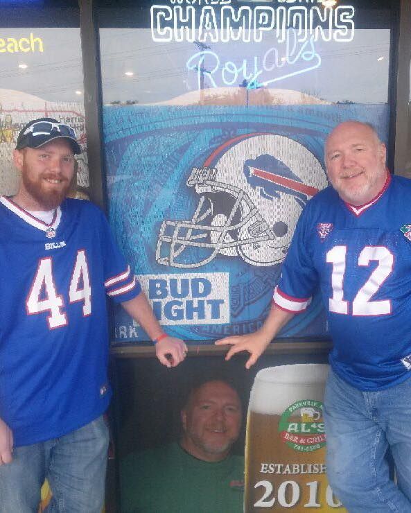 Two men standing in front of a bud light sign