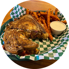 A grilled cheese sandwich and french fries in a basket on a table.