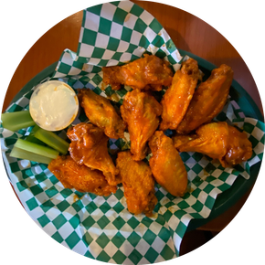 A plate of chicken wings with celery and ranch dressing