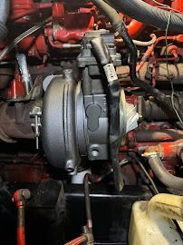 Turbocharger and engine components with red hoses in a vehicle engine bay