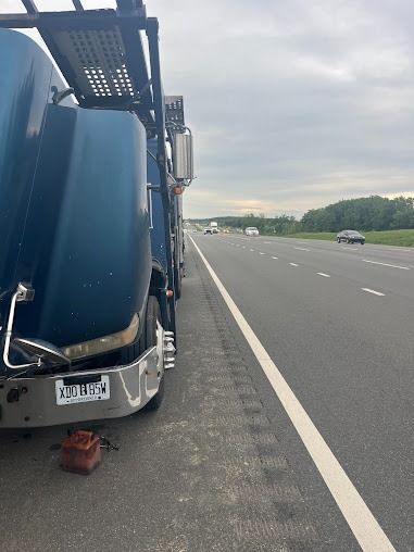 Overturned truck on highway shoulder beside empty lanes at dusk