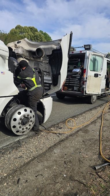 Open utility van with rear doors open, showing tools and supplies inside in a gravel lot.