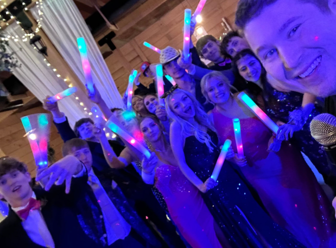 high school students dancing at school dance with glow sticks