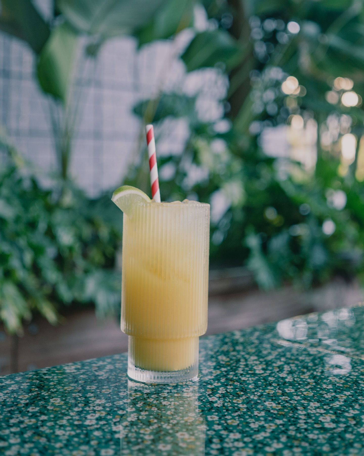 Yellow Cocktail in a Ribbed Glass With a Red-Striped Straw — Village Bicycle Noosa in Noosa Heads, QLD