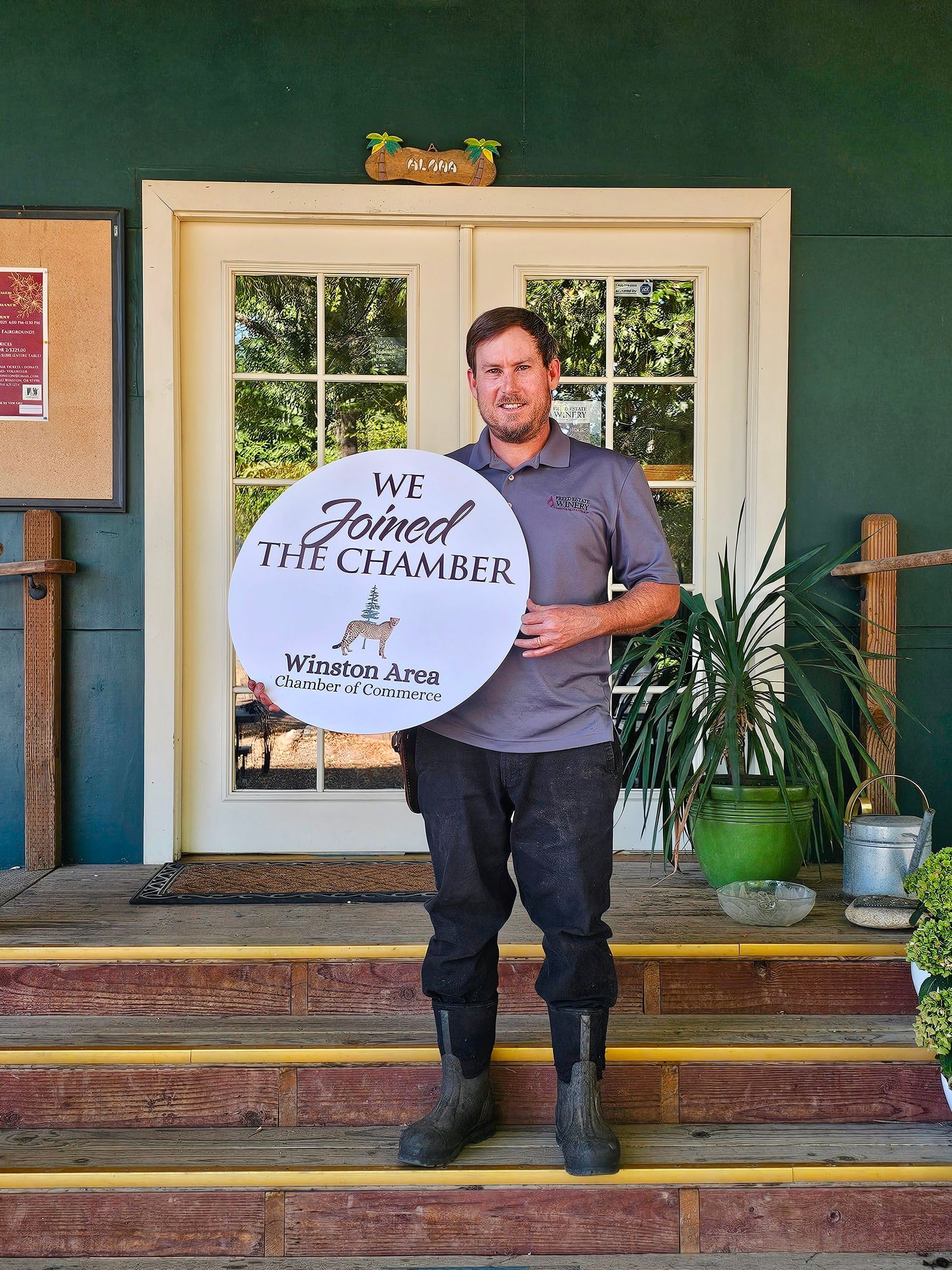A sign that says `` coming soon '' next to a branch of eucalyptus leaves.