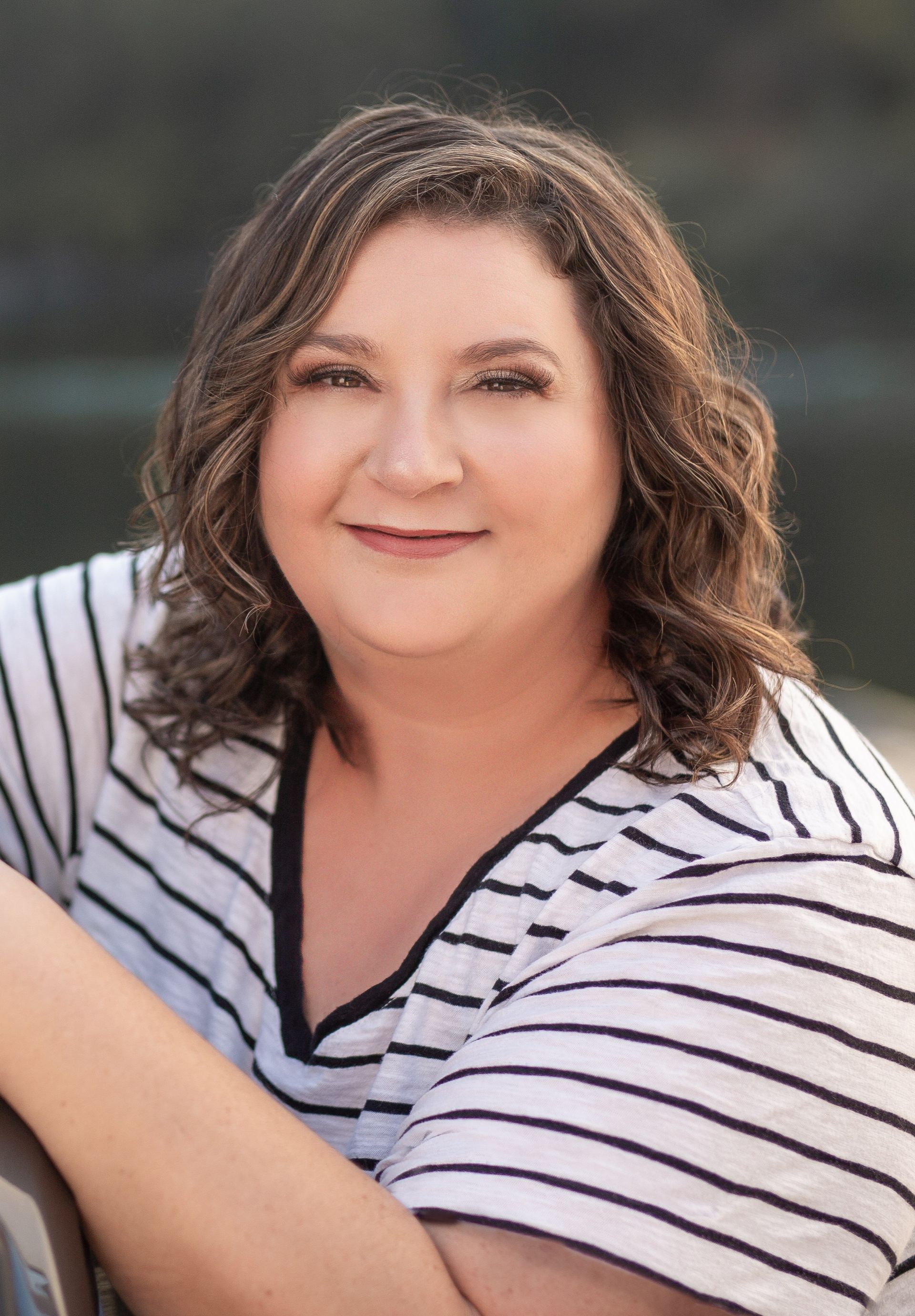 A sign that says `` coming soon '' next to a branch of eucalyptus leaves.