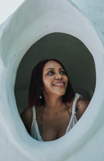 A woman is looking out of a hole in a wall.