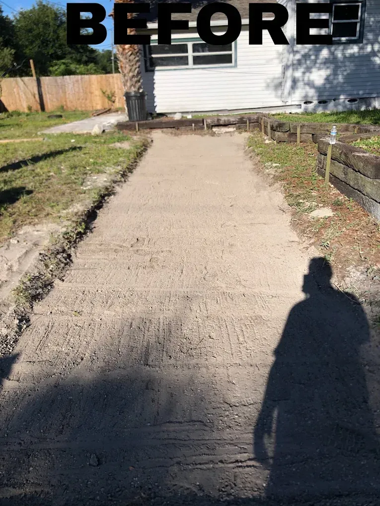 A gravel path, bordered by dirt, leads to a white house.