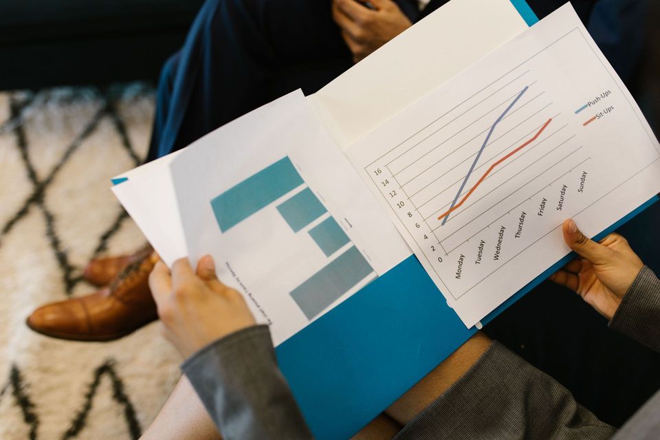 Hands holding a report with charts and graphs during a business meeting