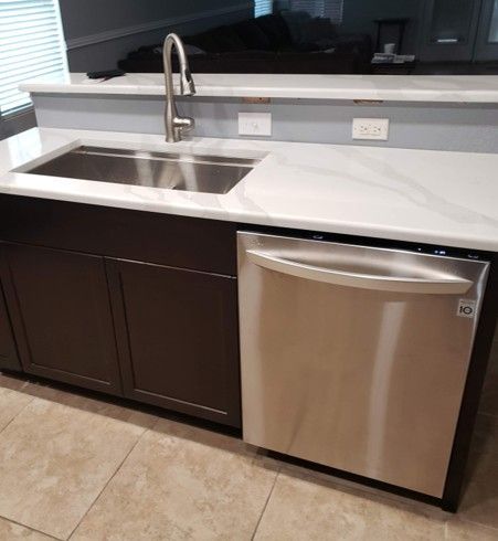 Kitchen: stainless steel sink, dishwasher, dark brown cabinets, white countertop.