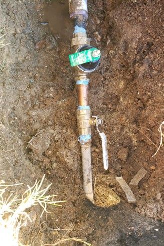A buried irrigation system with a valve, located in dirt and soil.