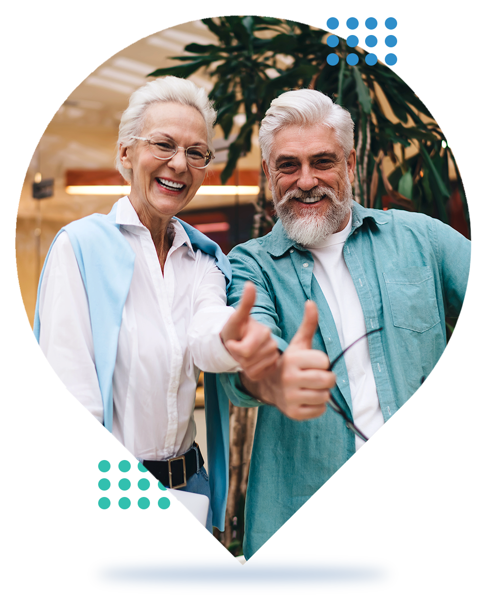 Smiling couple in a heart frame, giving thumbs up, with blue and teal decorative dots