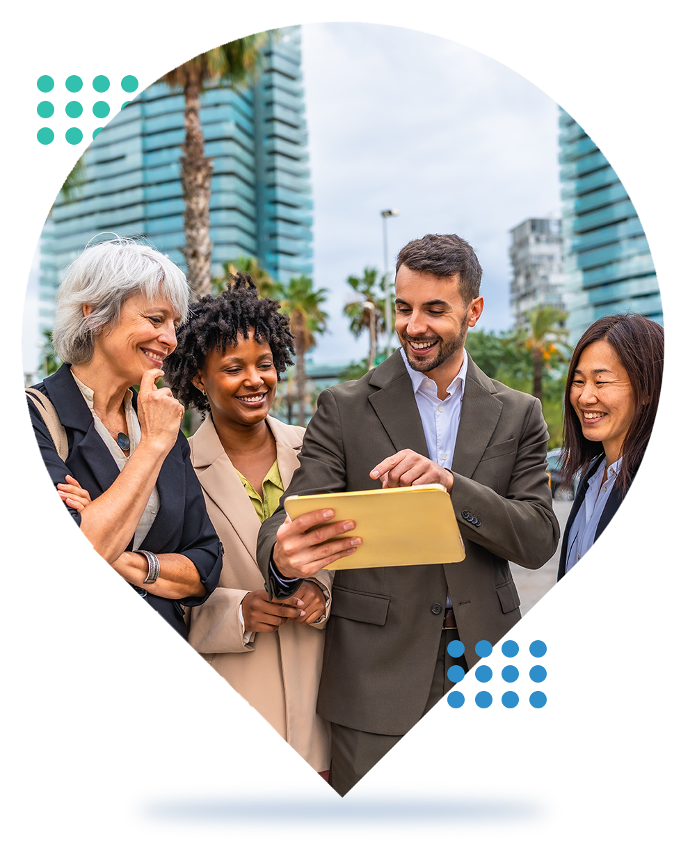 Four professionals reviewing a folder together outdoors, with office buildings in the background.