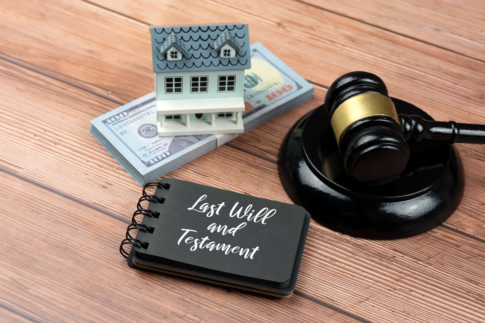 Miniature house, money, gavel, and notebook (