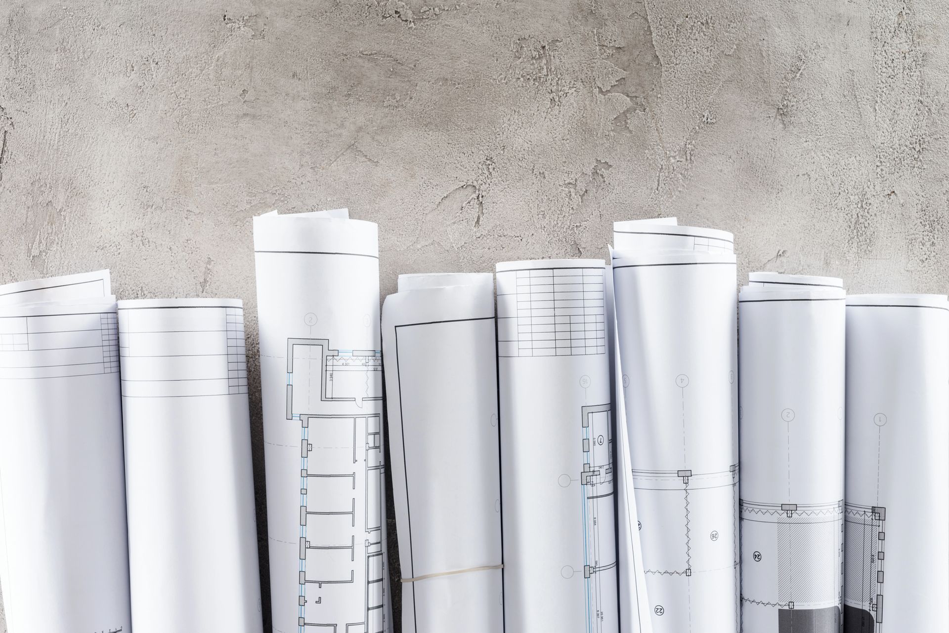 Fogli arrotolati di carta o cartone beige, impilati strettamente uno sull'altro, in una vista ravvicinata.