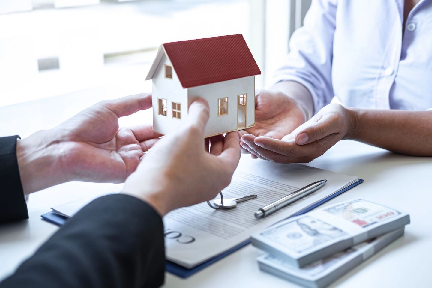 Mani che disegnano una planimetria su disegni architettonici con matita e righello