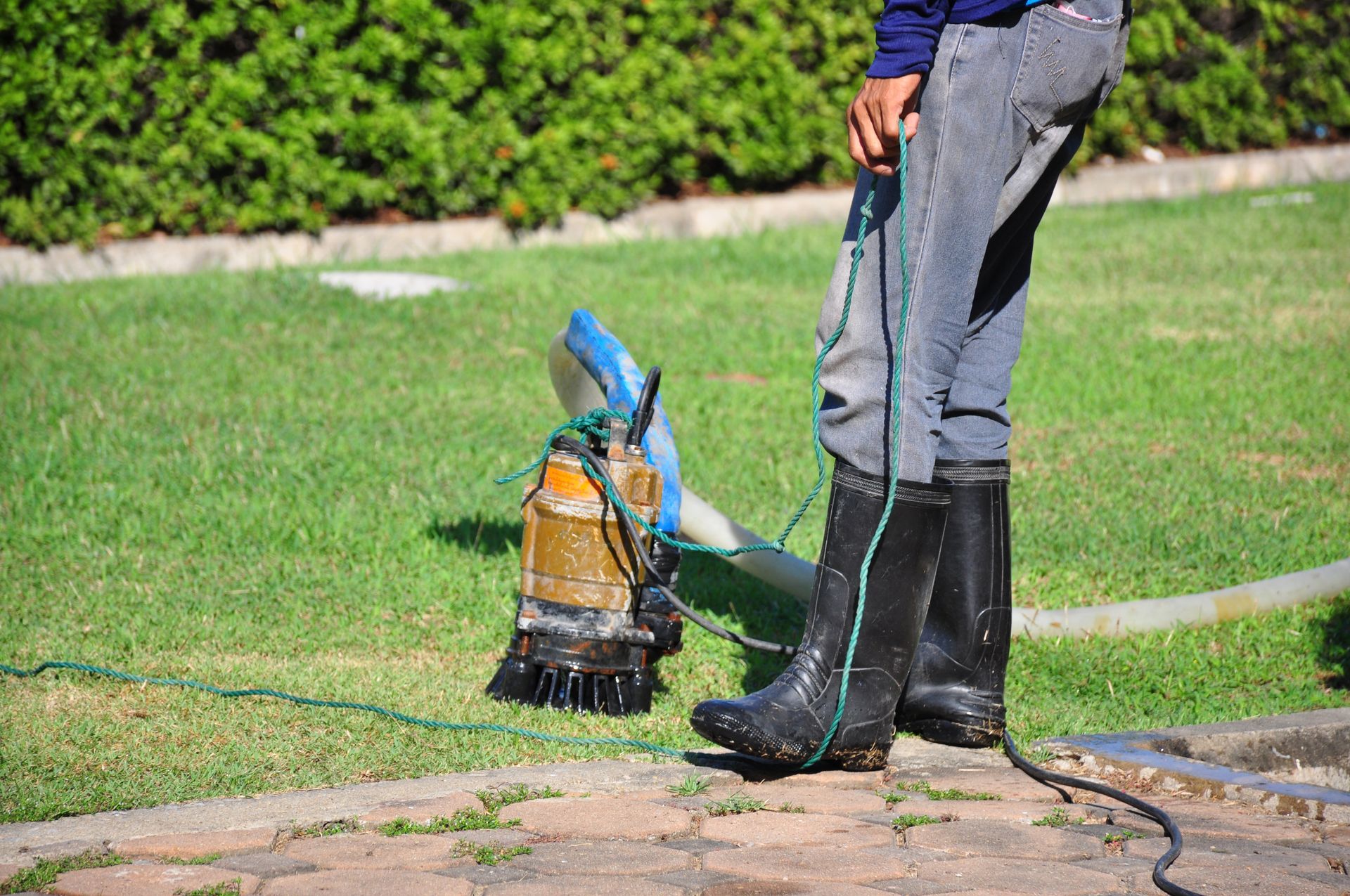 A man is standing next to a vacuum cleaner in a yard.