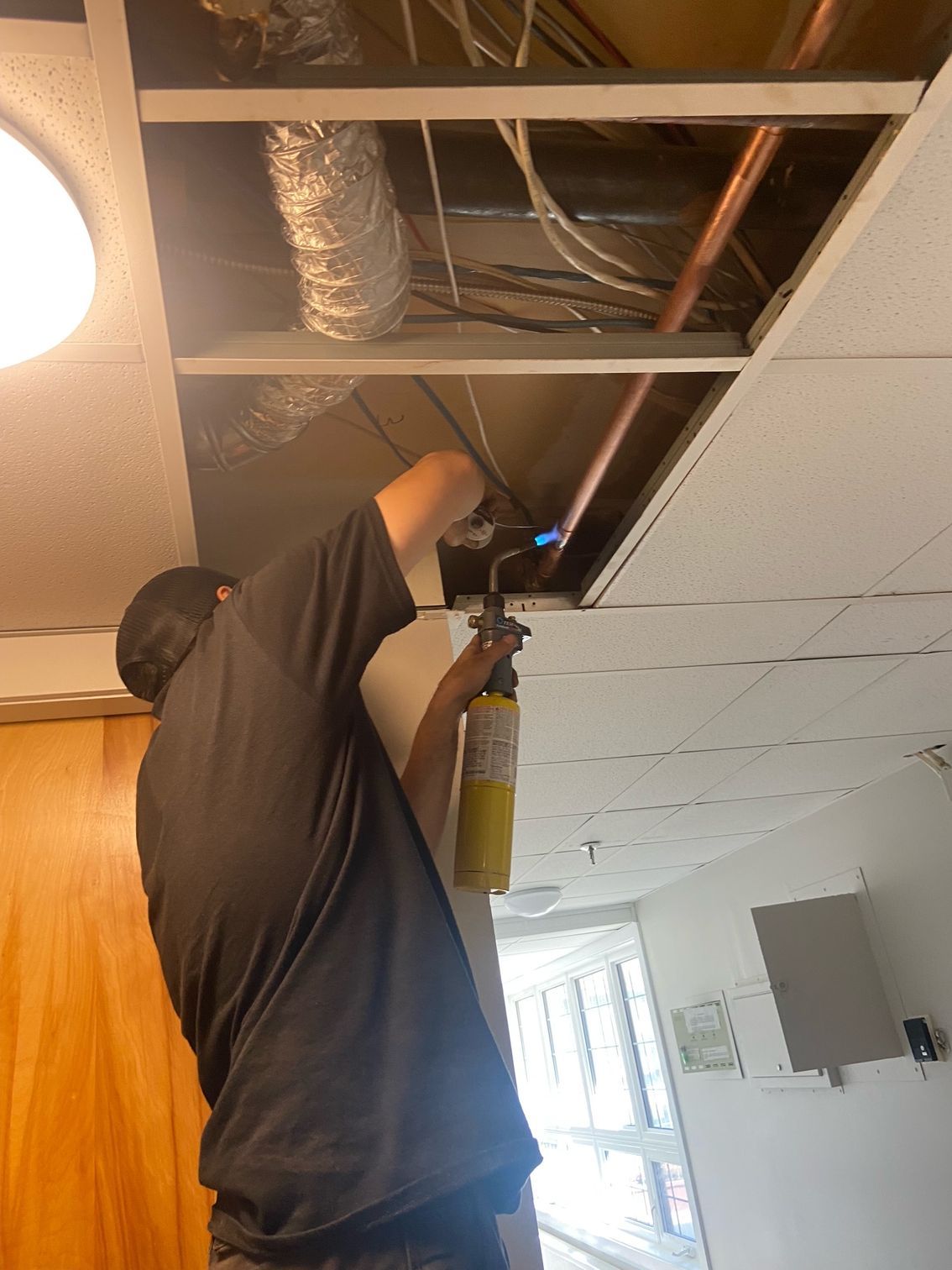 A man is working on a ceiling with a torch.