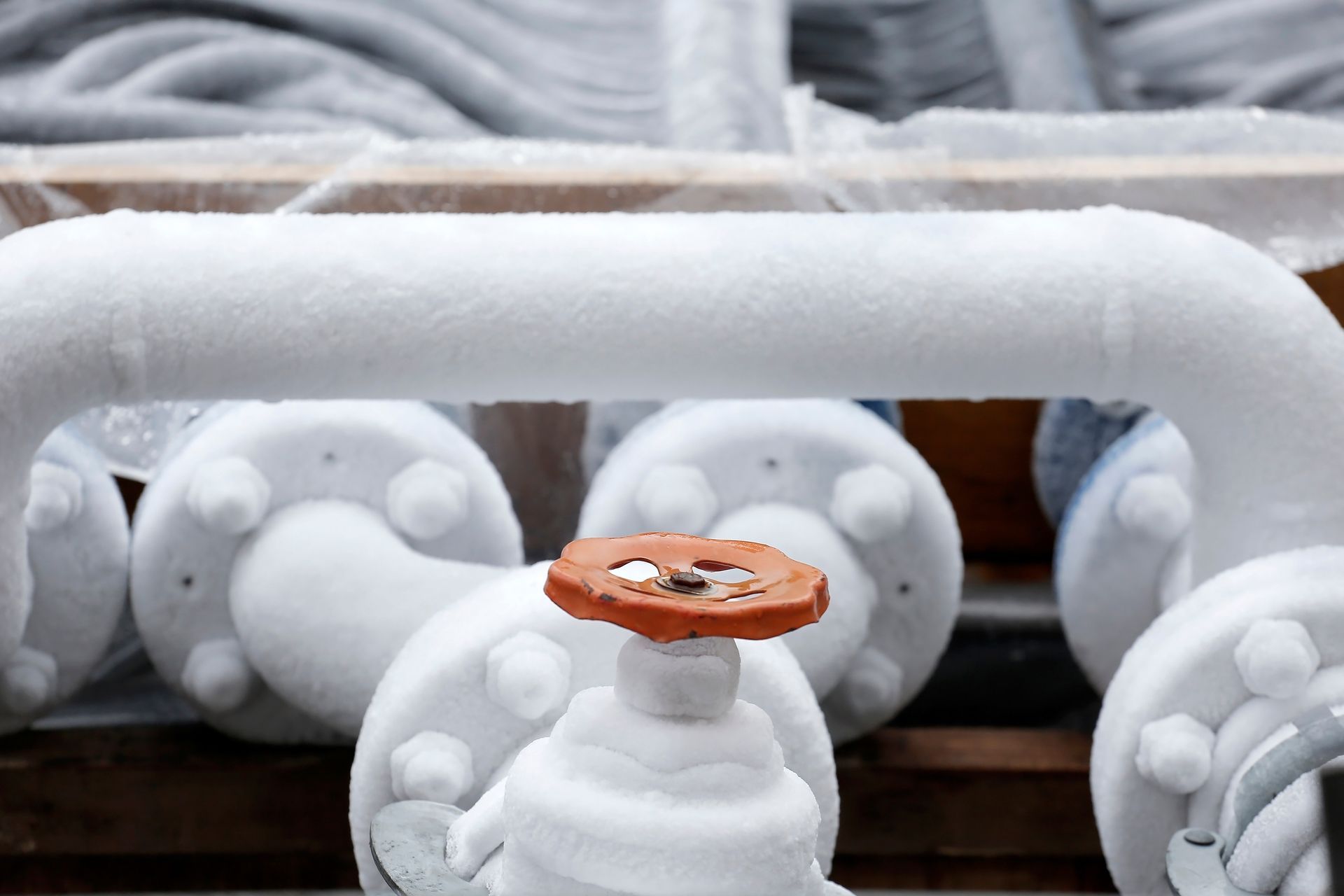 A close up of a frozen pipe with a valve on it.