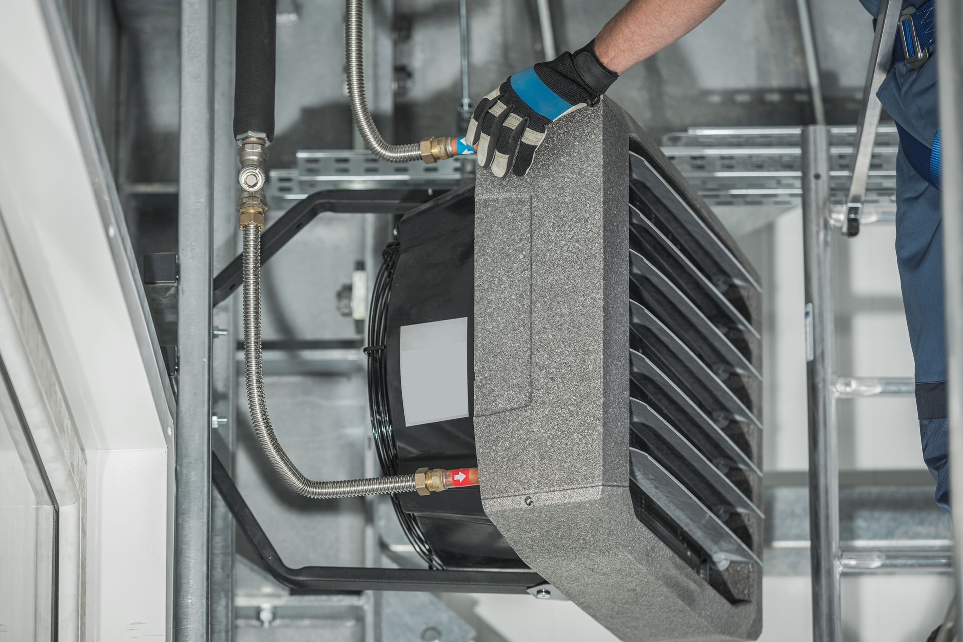 A man is working on a heater in a building.