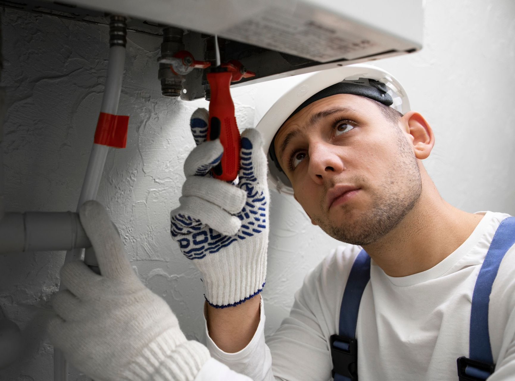 a car heater is sitting in a garage next to two cars .