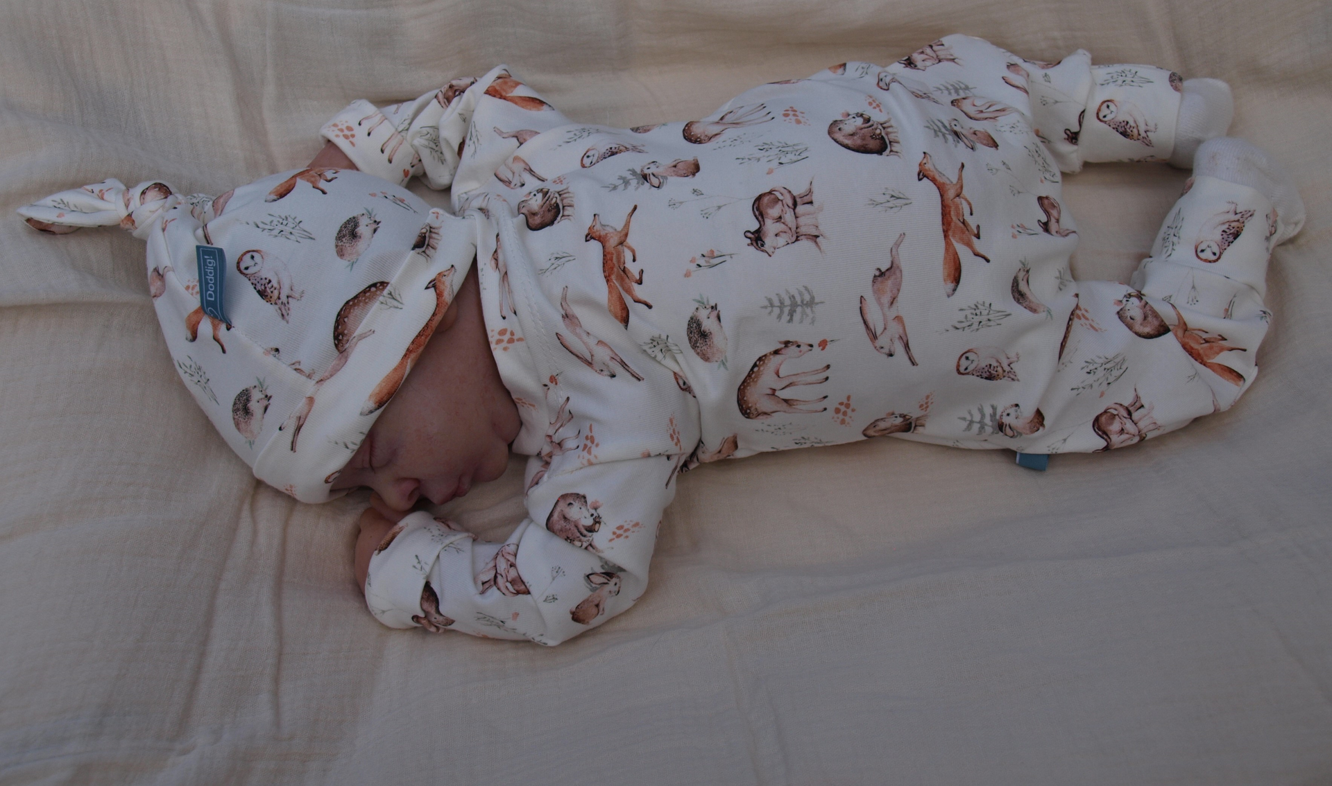 Roomwit babypakje met bosfiguurtjes in natuurlijke tinten