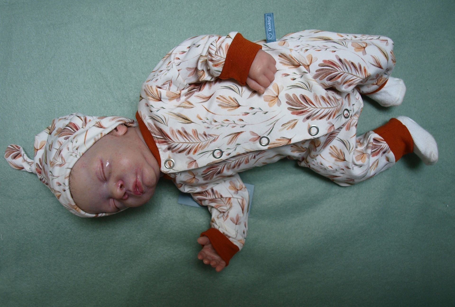 Newborn, Babypakje met mutsje, drukkers en takjes en roestkleurige boordjes