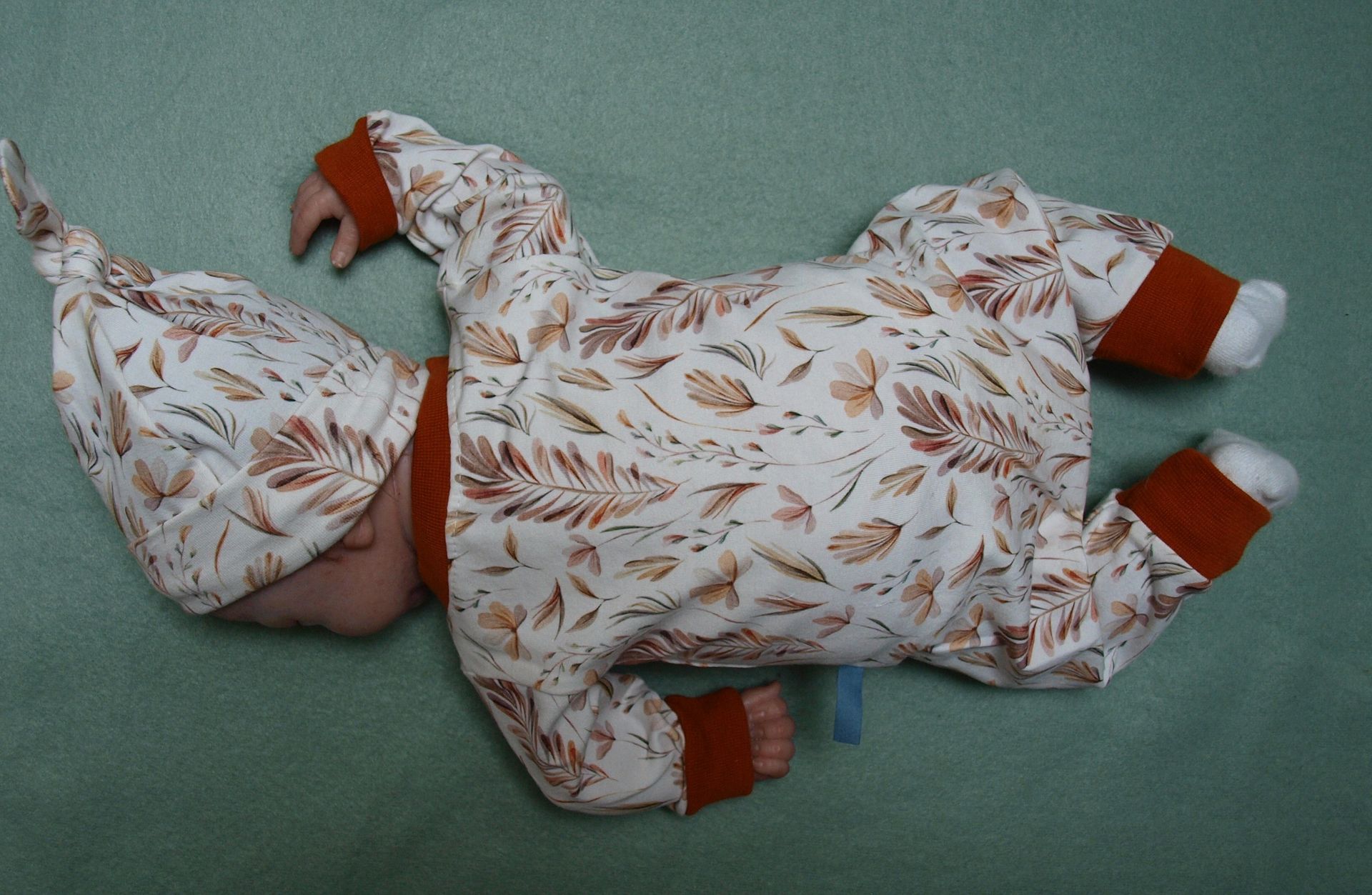 Newborn, Babypakje met mutsje, drukkers en takjes en roestkleurige boordjes