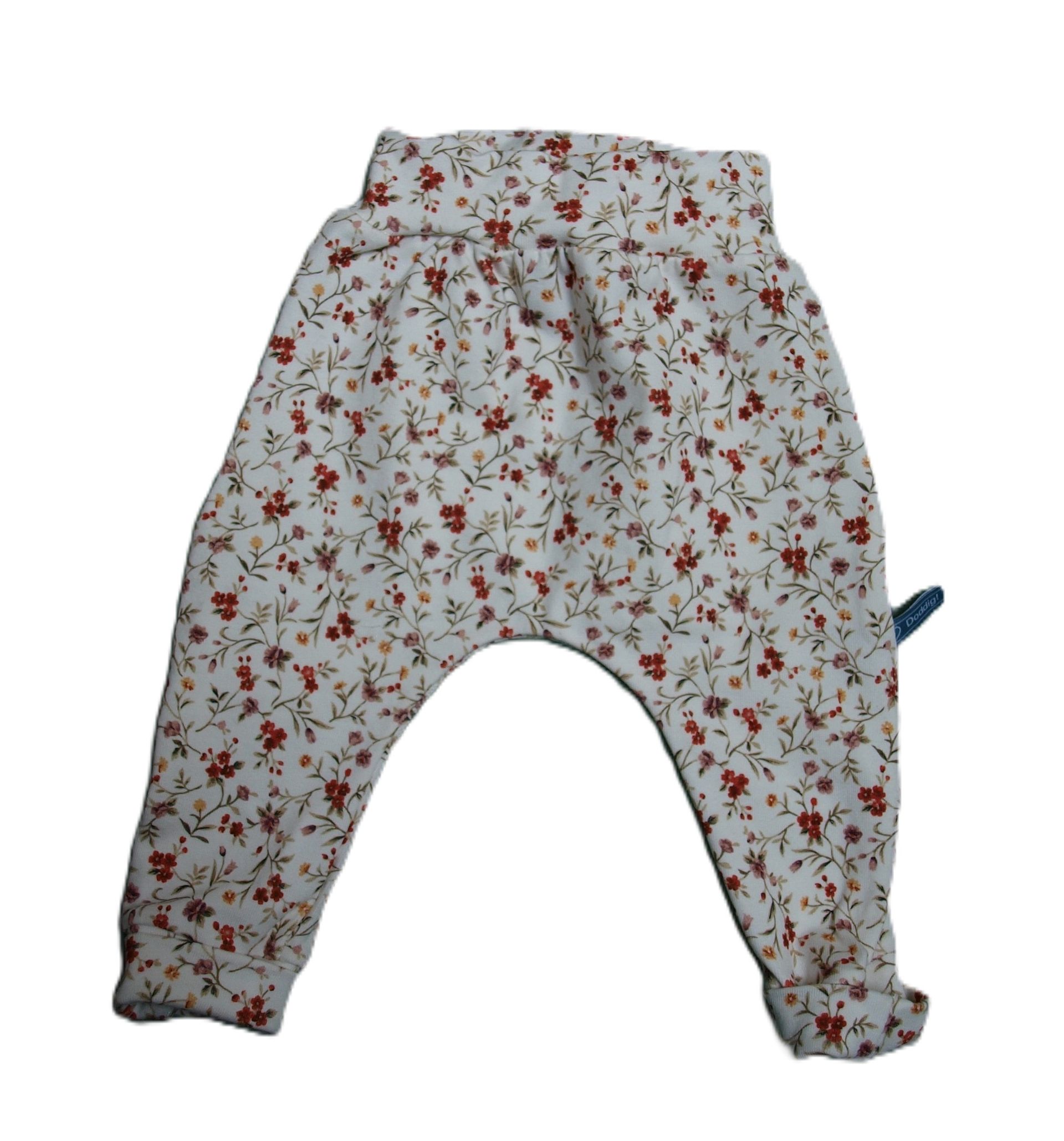 Een room-wit babybroekje met  kleine bloemetjes erop maat 56