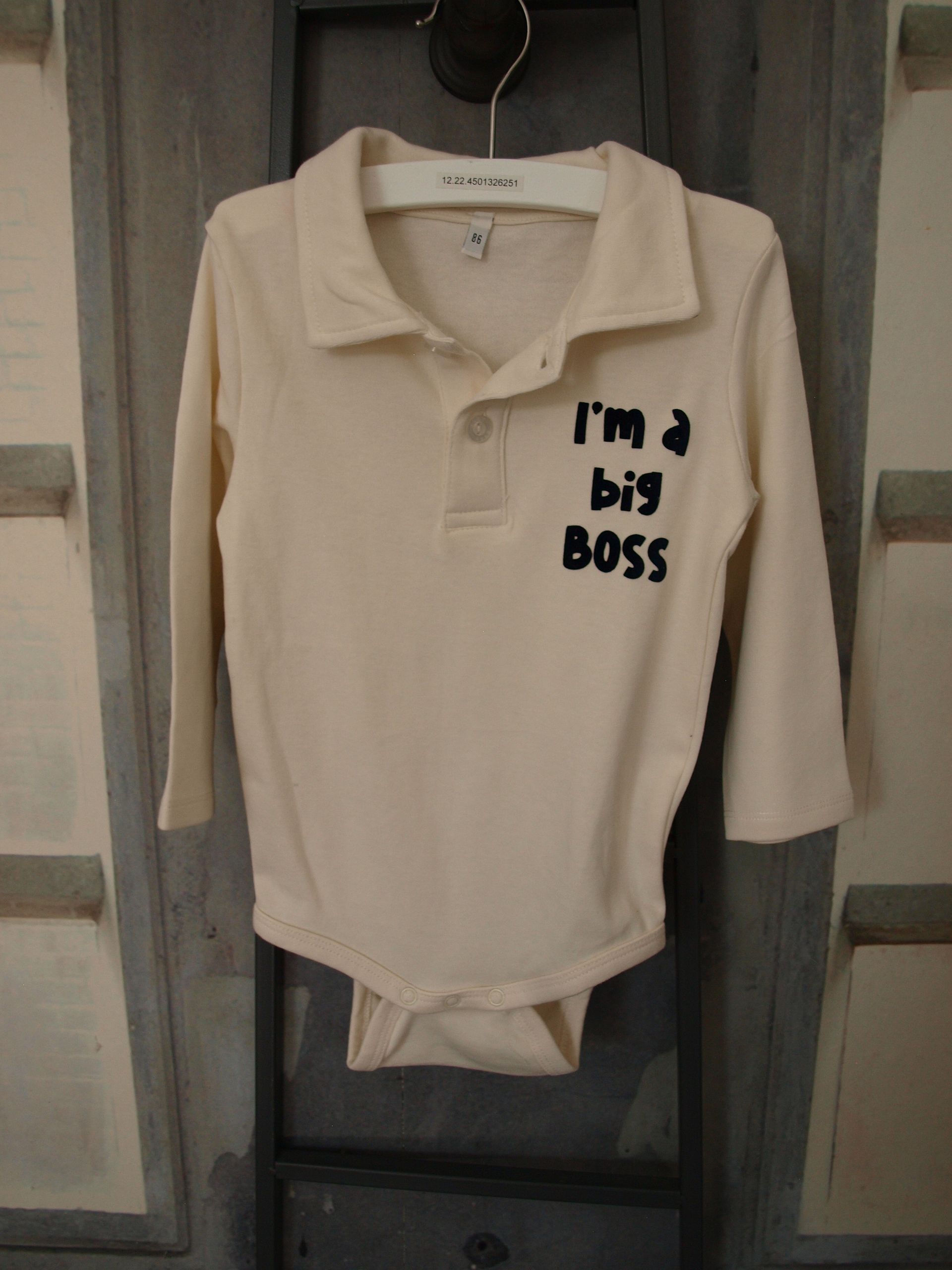 Roomwit rompertje voor jongetjes met lange mouwen, polokraag en knoopsluiting. Bedrukt met een zwarte tekst:  Im a big bos.