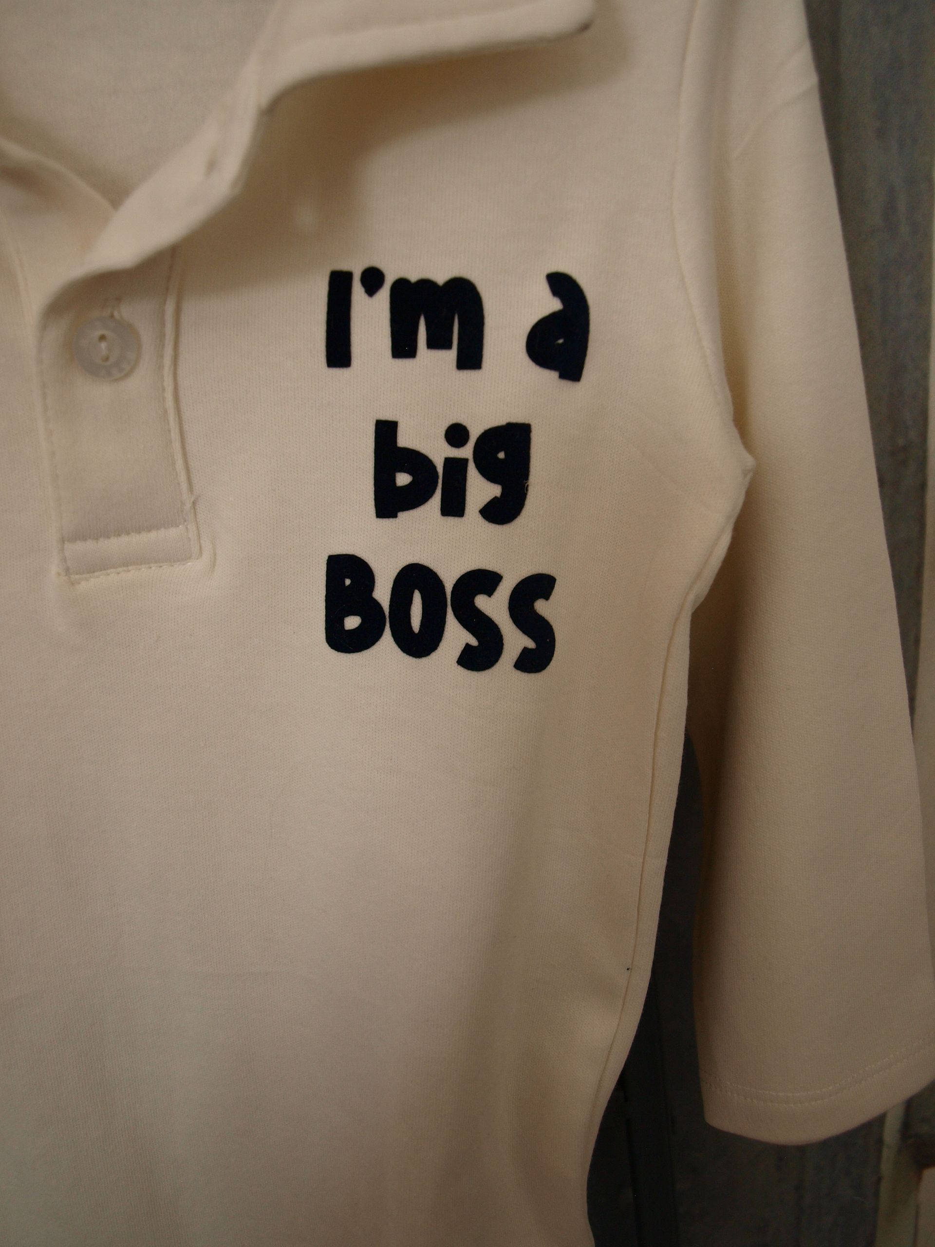 Roomwit rompertje voor jongetjes met lange mouwen, polokraag en knoopsluiting. Bedrukt met een zwarte tekst:  Im a big bos.