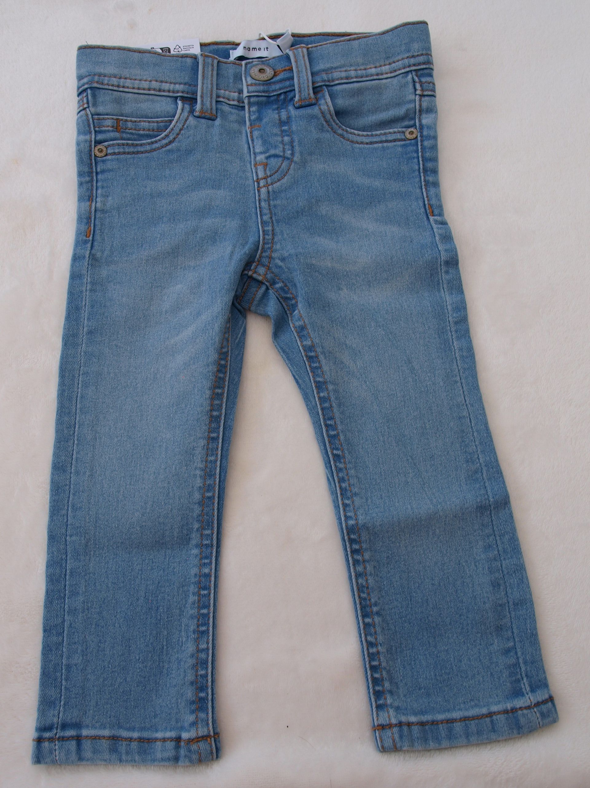 Een lichtblauwe spijkerbroek op een wit oppervlak