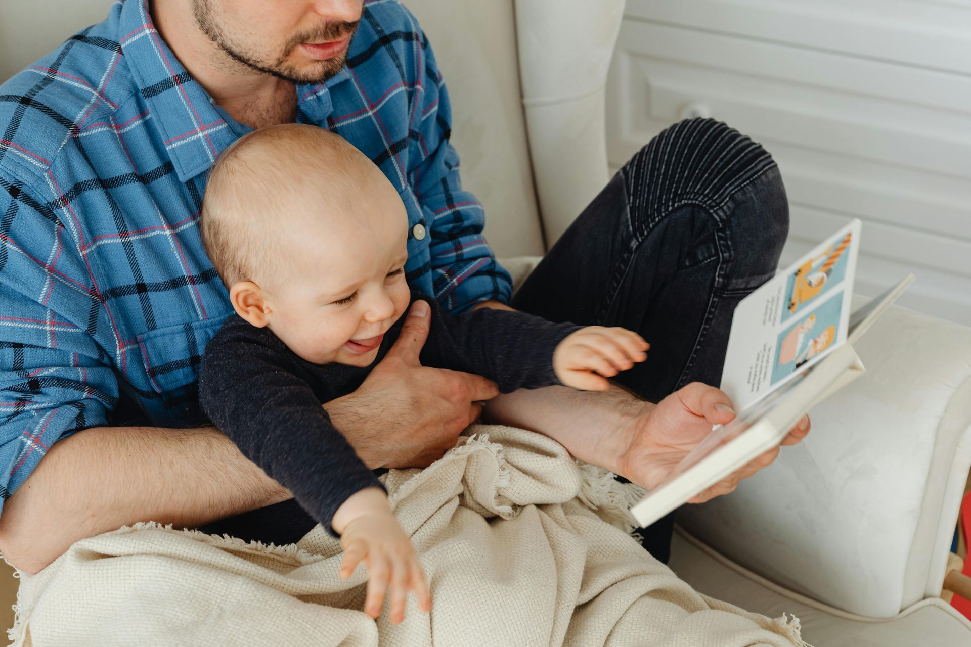 Vader leest baby voor uit leesboekje, een vader zoon momentje