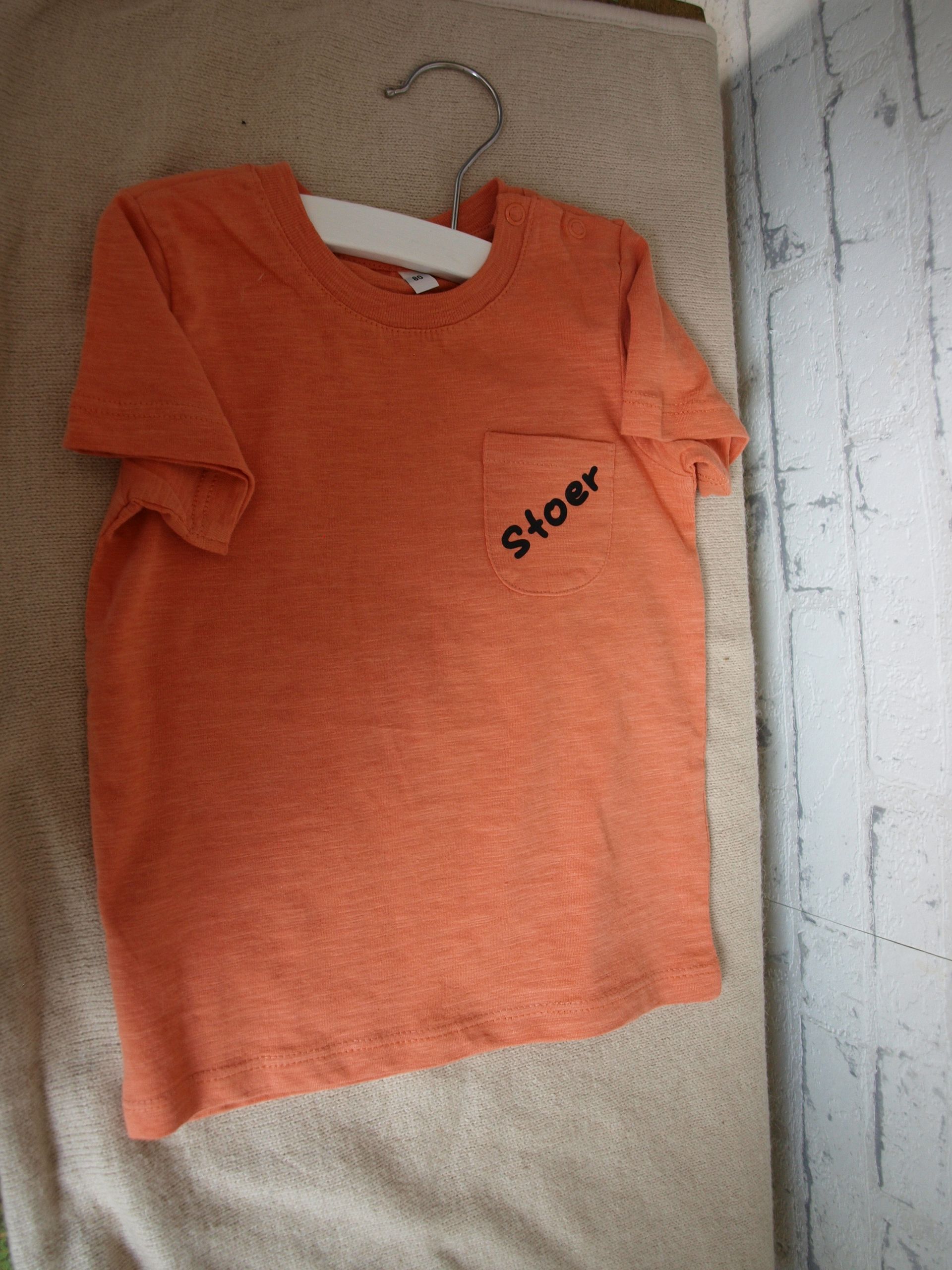 Een oranje t-shirt met daarop de tekst 'stoer', maat 80