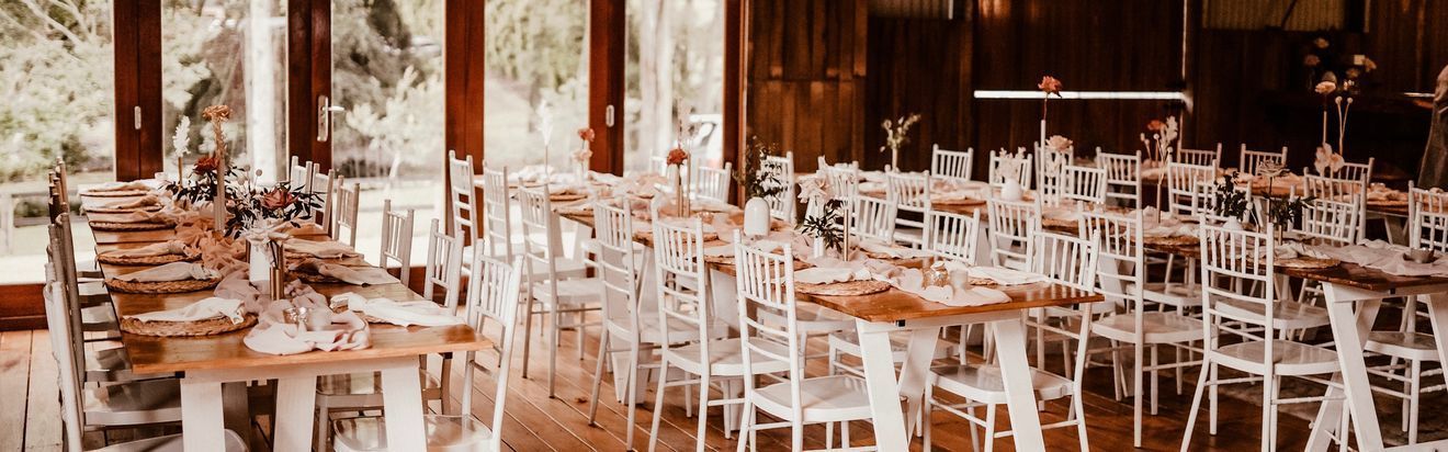 Elegant dining table set with flowers, candles, glassware, and menus.