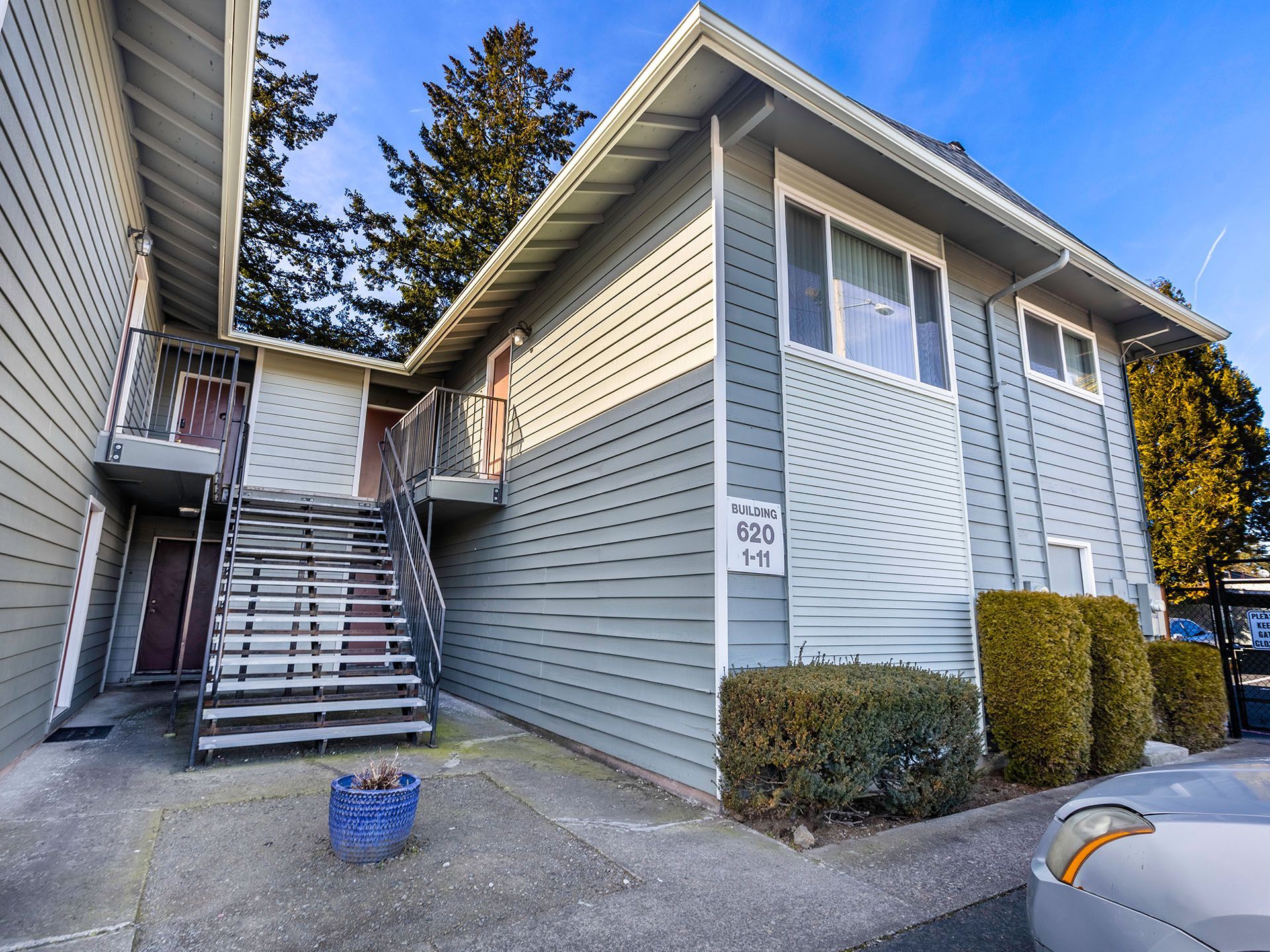 Photo of a building showing several apartment entrances and a flight of stairs