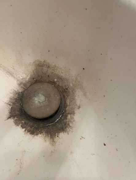 A close up of a drain hole in a bathroom sink need cleaning services Boone NC