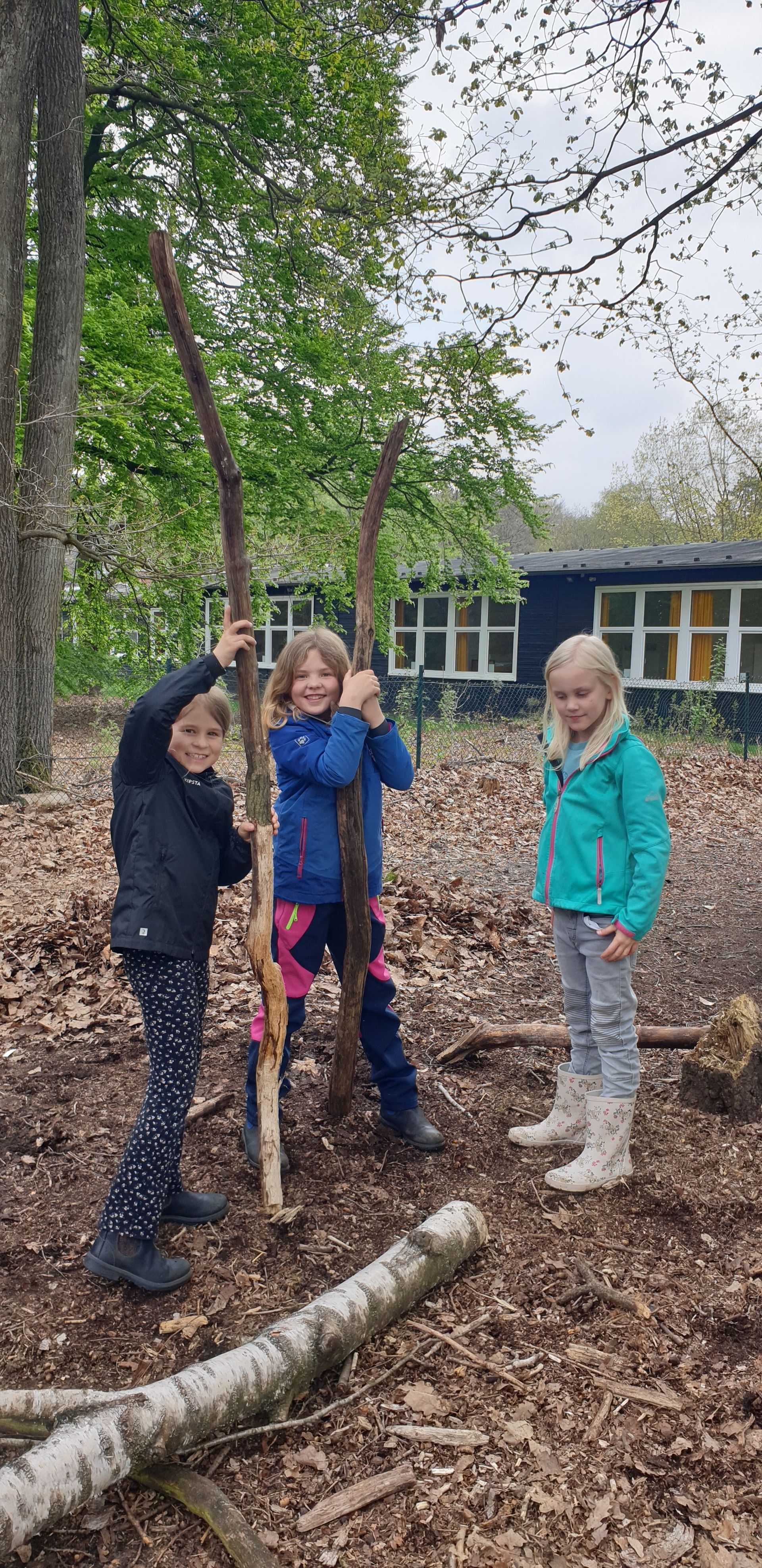 Kinder spielen mit Ästen
