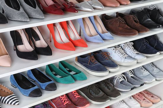 Shelving unit with different shoes. Element of dressing room interior