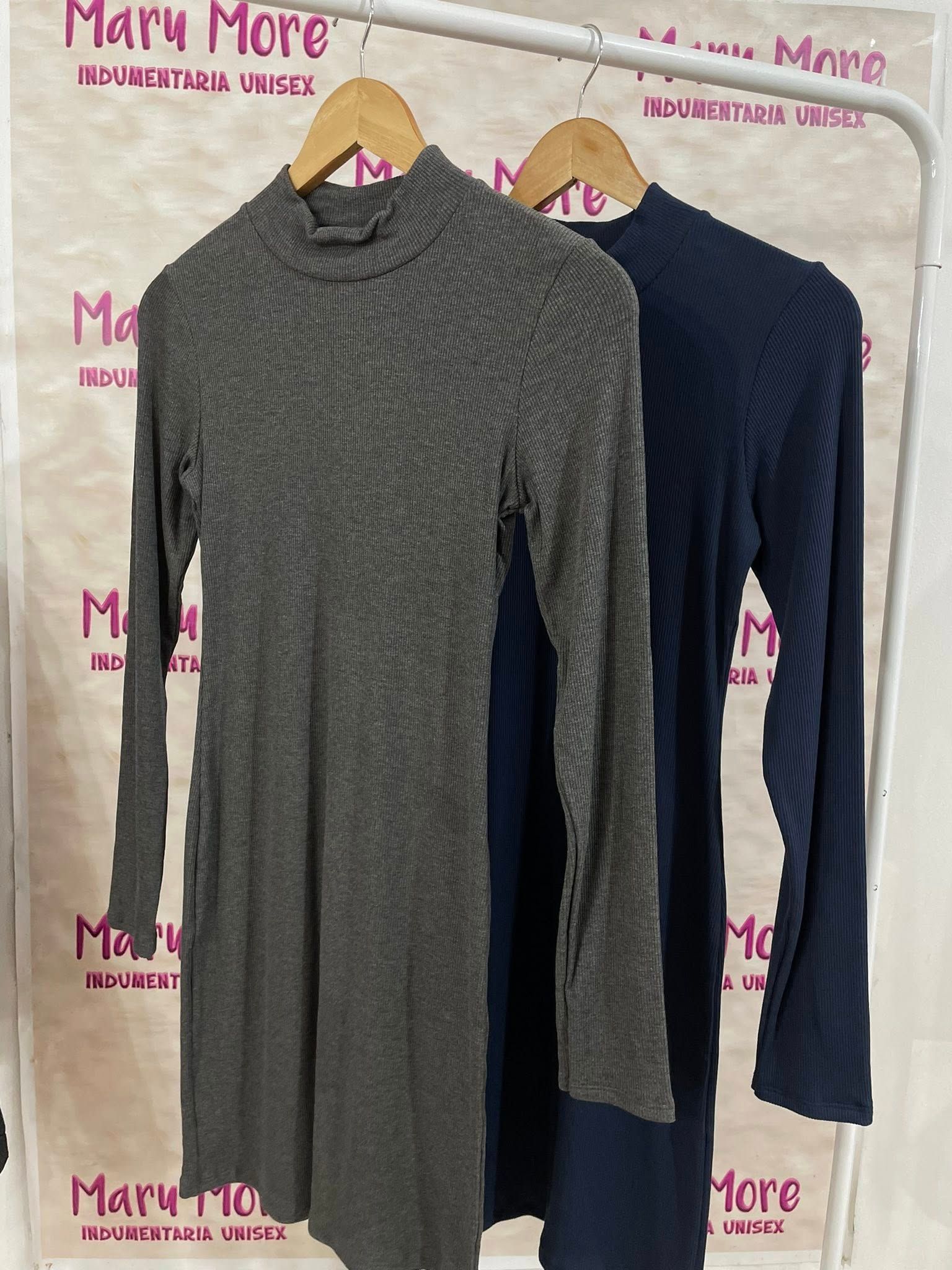 Un vestido azul con mangas largas está colgado en una percha.