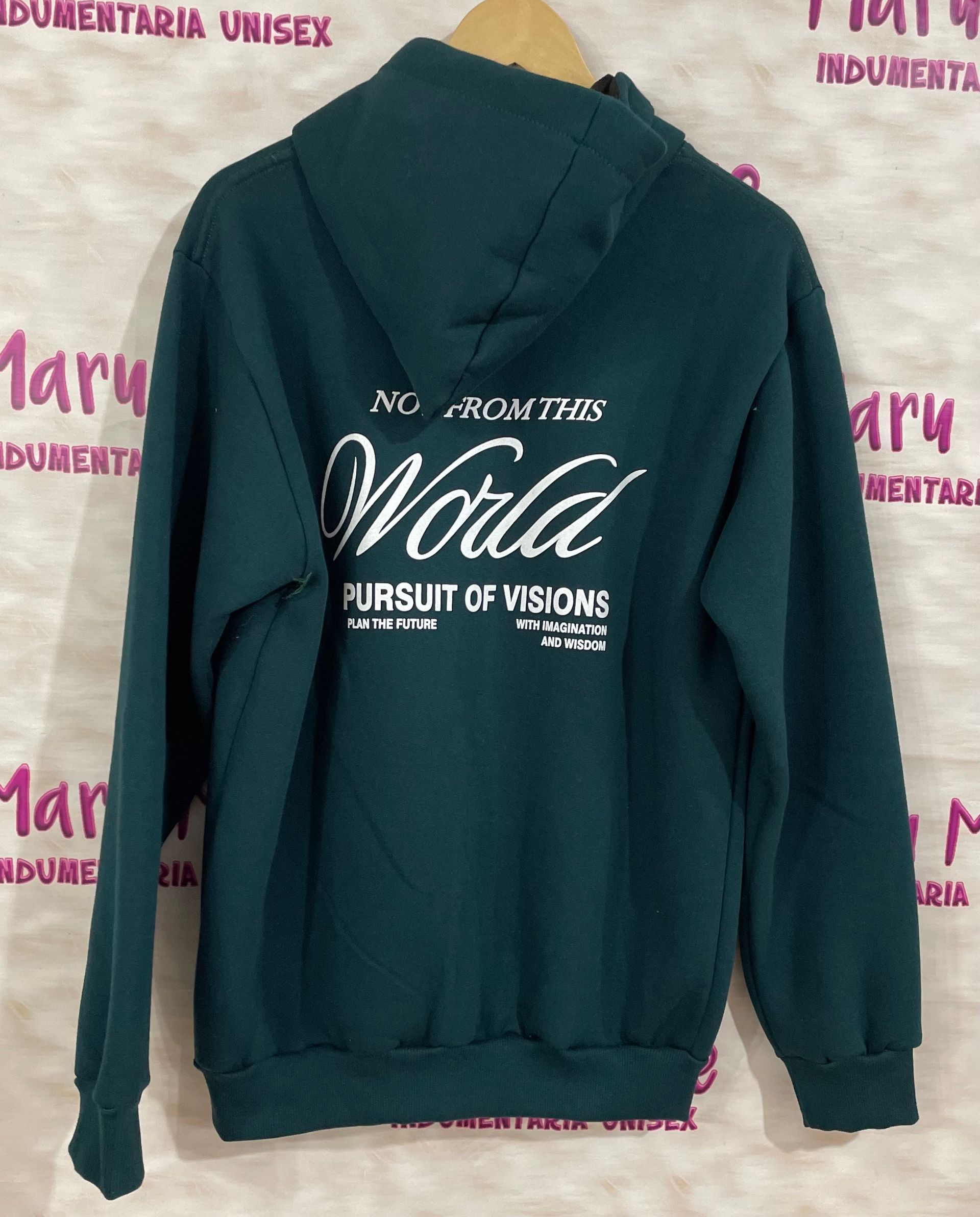 Una sudadera con capucha verde cuelga de una percha frente a un cartel que dice maru more